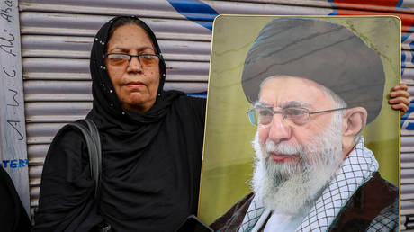 A Kashmiri woman holds a portrait of Iran's late Supreme Leader Ayatollah Ali Khamenei during a Muharram procession on in Srinagar on July 11, 2026.