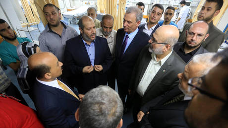 Hamas' Khalil al-Haya (L2) and then-Minister of Housing and Public Works of Palestinian National Consensus Government Mufid al-Hasayni (L), visit wounded Palestinians at Al-Shifa Hospital, in Gaza city, Gaza on 14 August, 2014.