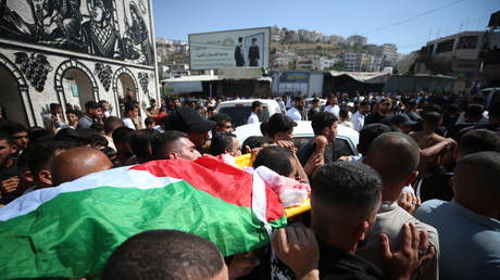 Mourners carry the body of 17-year-old Karim Sanad Shalaldeh during his funeral procession in Sa’ir near Hebron, West Bank, August 21, 2026.