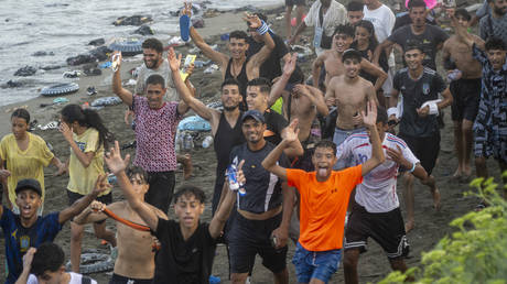 Dozens of migrants celebrate having crossed the border from Morocco in Ceuta, Spain, July 31, 2026