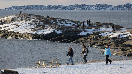 FILE PHOTO: People stroll along a snow-covered shore at a fjord on January 25, 2026 in Nuuk, Greenland.