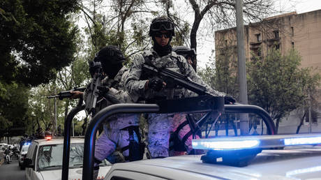 Members of Mexico's National Guard Special Forces guard the transfer of a forensic ambulance in Mexico, February 22, 2026.