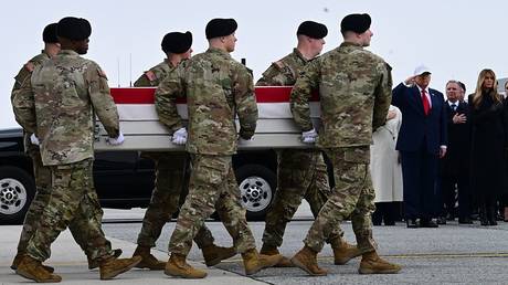 A US Army carry team moves flag-draped coffins containing the remains of US soldiers killed in an Iranian retaliatory strike on Kuwait’s Port of Shuaiba, Dover, Delaware, March 7, 2026.