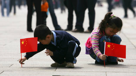 FILE PHOTO: Children holding play in Tiananmen Square in Beijing, China