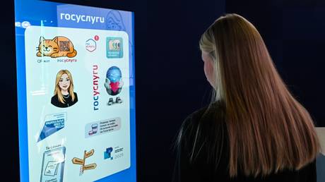 A young woman looks at the stand of Gosuslugi at an exhibition in Moscow.