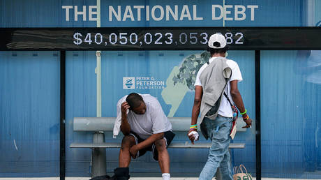 A sign displays the US national debt at a bus stop on August 20, 2026 in Washington, DC. © Getty Images / Anna Moneymaker