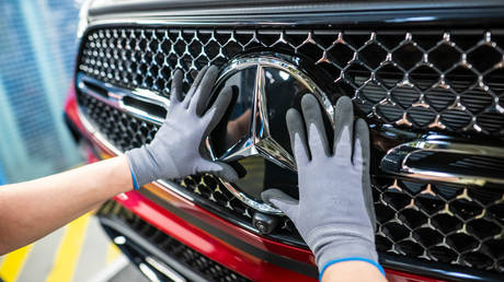 An employee working on an assembly line of a Mercedes-Benz plant.