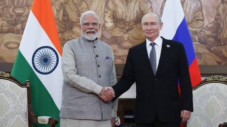 Indian Prime Minister Narendra Modi and Russian President Vladimir Putin shake hands as they pose for photos before a meeting on the sidelines of the Shanghai Cooperation Organization (SCO) summit in Bishkek, Kyrgyzstan.
