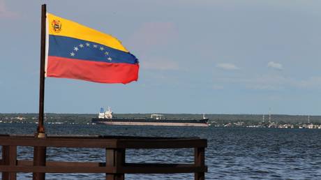 FILE PHOTO: A Venezuelan flag waves in front of oil tanker in Maracaibo, Venezuela on July 27, 2026