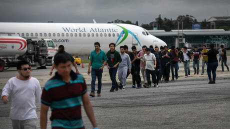 FILE PHOTO: Migrants disembarking from a plane after a deportation flight from the US.