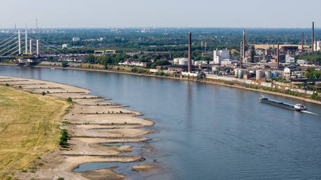Cargo ships navigate the low Rhine near Duisburg, Germany, as exposed sandbars line the riverbanks during a prolonged heatwave and drought, July 30, 2026.