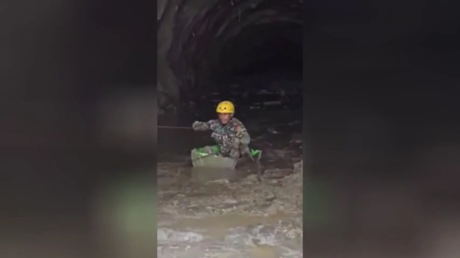 Nepali Army soldier navigating the mud-filled Chilime hydropower tunnel as he looks for survivors of the flash flood.
