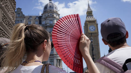 A visitor fans herself in front of Parliament during a heatwave in London on June 19, 2026.