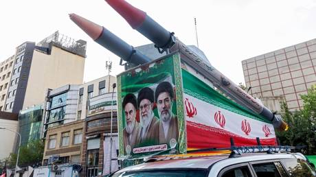 A car displaying missile replicas and images of Iran’s supreme leaders during a gathering in Tehran on August 12, 2026.
