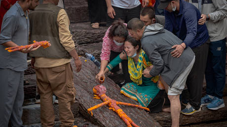 A relative mourns during the symbolic cremation of four members of the Magar family who remain missing after the flash floods, at the Pashupatinath Temple in Kathmandu on September 2, 2026.