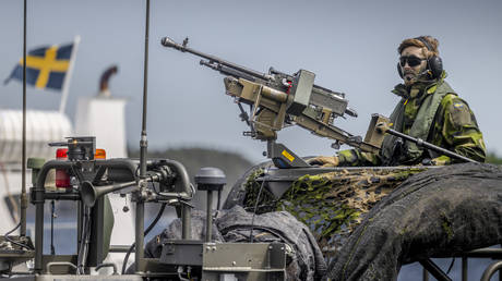 A Swedish soldier sits on a military boat with a machine gun during the Baltic Operations NATO military drills (Baltops 22) on June 11, 2022, in the Stockholm archipelago.