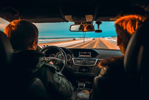 Young driver traveling with a passenger on a countryside road