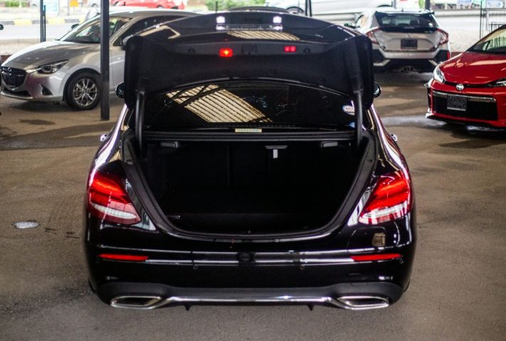 Black sedan with its trunk open inside a car dealership