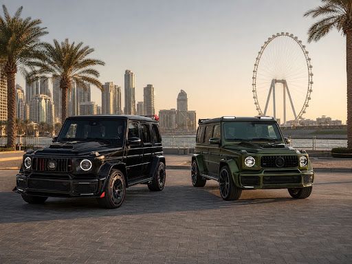 Two customized Mercedes G-Class SUVs, one black and one dark green, parked on a waterfront promenade with palm trees, high-rise buildings, and a large observation wheel.