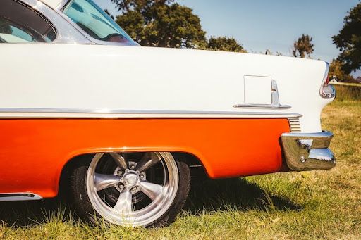 Vintage white and orange car with chrome details on grass