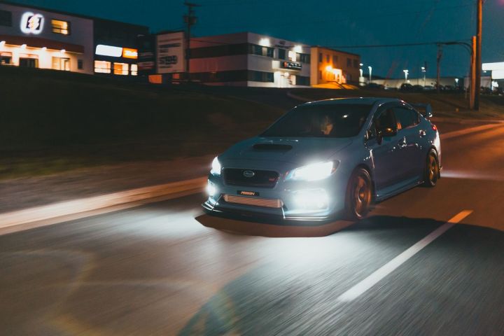 Blue Subaru WRX driving at night for an article about driving after drinking