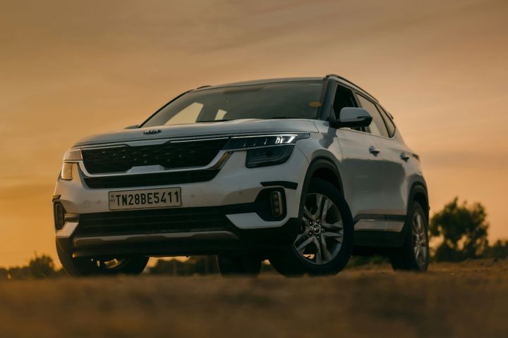 White Kia SUV parked outdoors at sunset