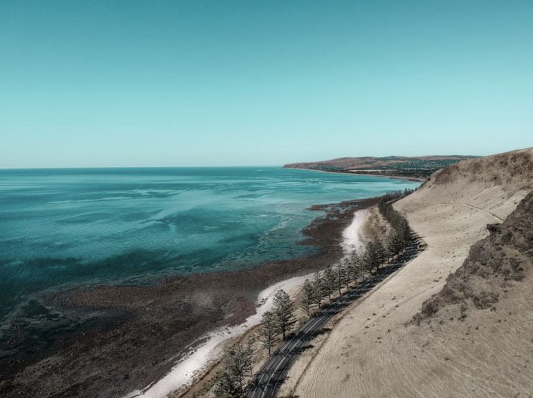 A car driving on an open coastal highway in Australia